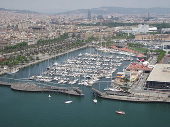 High angle view of boats in river with city in background