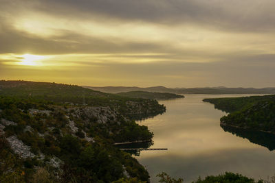 Scenic view of river against sky during sunset