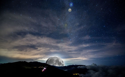 Scenic view of mountains against sky at night