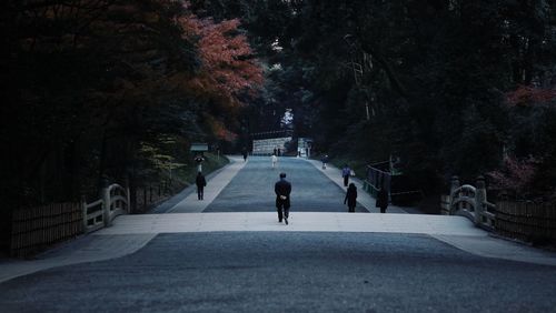 Rear view of man walking on road in city