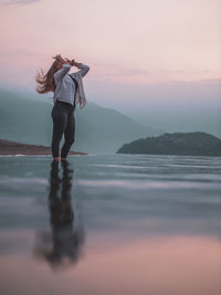 Full length of man standing at sea shore against sky