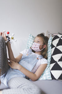 Close-up of girl holding toys on bed