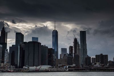 Skyscrapers in city against cloudy sky