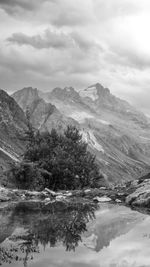 Scenic view of river by mountains against sky