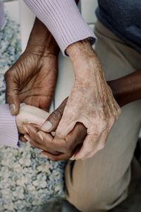 Midsection of senior man and woman holding hands