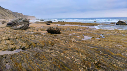 Rocks on beach against sky