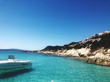 Boat on sea against clear blue sky