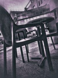 Man sitting in empty chairs and table in building