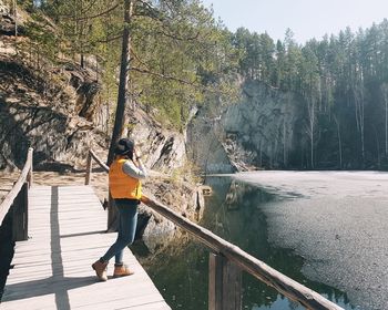 Rear view of woman standing on footbridge