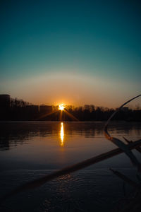 Scenic view of lake against clear sky during sunset