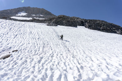 Man on snow covered mountain against sky