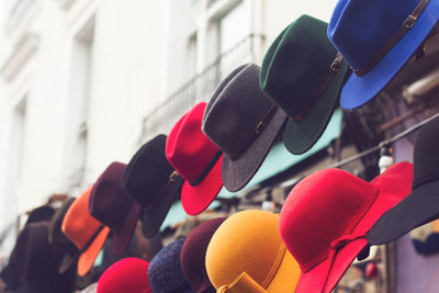Low angle view of multi colored hats hanging for sale
