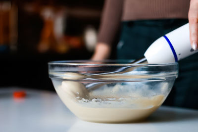Close-up of hand holding drink on table