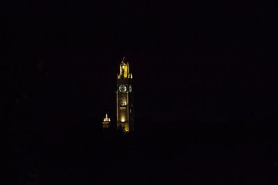 Low angle view of clock tower at night