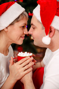 Young couple drinking coffee at xmas tree. couple relaxing