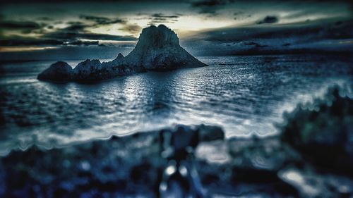 Close-up of rock on sea shore against sky