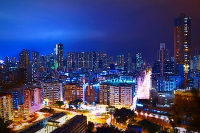 Illuminated modern buildings against sky at night