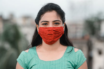 Portrait of young woman standing in city