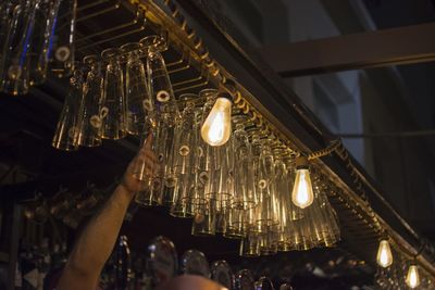 Low angle view of illuminated lighting equipment hanging at ceiling