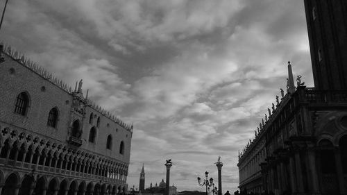 Low angle view of buildings against cloudy sky