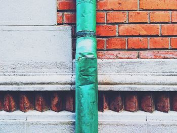 Close-up of pipe against brick wall