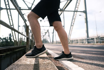 Low section of man standing on bridge