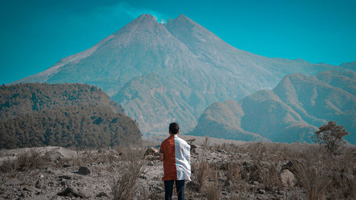 Rear view of man standing on mountain landscape