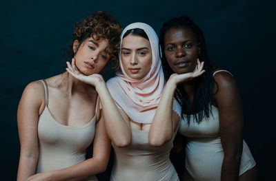 Women standing against black background