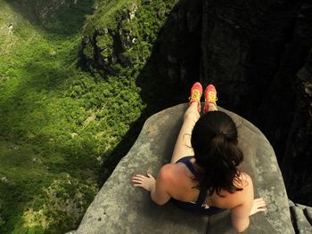 Overhead view of woman sitting on cliff