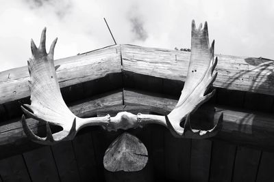 Low angle view of cross on roof against sky