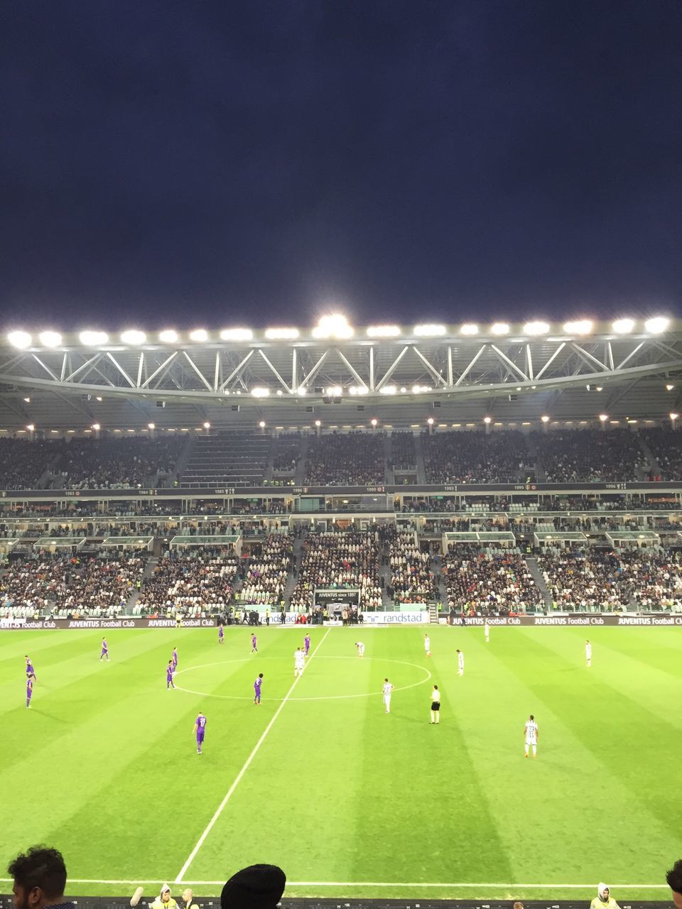 grass, large group of people, night, sport, green color, field, landscape, illuminated, leisure activity, sky, men, playing field, arts culture and entertainment, stadium, outdoors, grassy, lifestyles, soccer, crowd