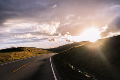 Road amidst landscape against sky during sunset