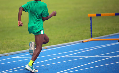 Low section of man running on track