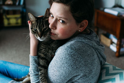 Portrait of woman with cat at home