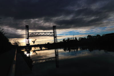 View of harbor against cloudy sky at dusk