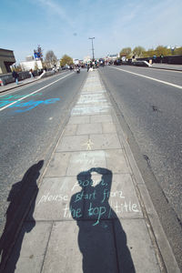 Shadow of person on road in city