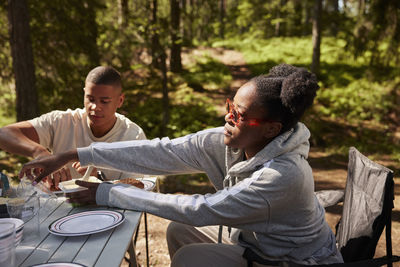 Friends eating meal at camp site