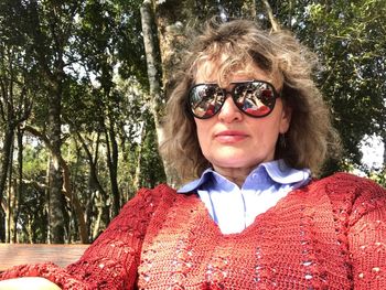 Close-up of woman wearing sunglasses against trees