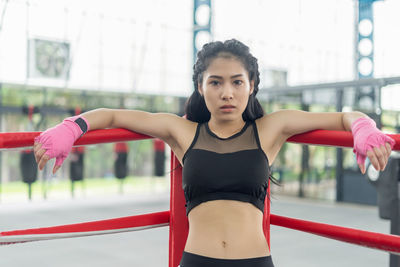 Young woman with arms raised standing in background