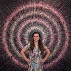 Portrait of smiling woman standing against patterned wall