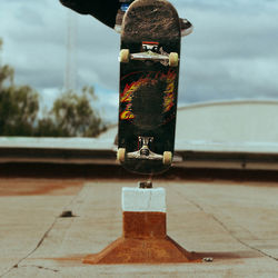 Low section of person performing stunt on skateboard