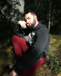 Man wearing sunglasses on field in forest