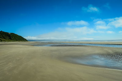 Scenic view of beach against blue sky