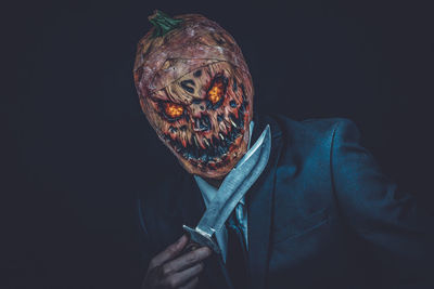 Close-up of man with halloween make-up against black background