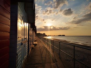 Beach huts sunset with pier in background