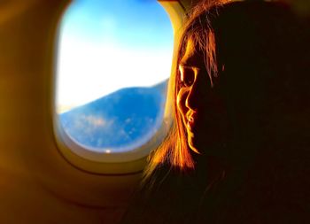 Portrait of woman looking through window
