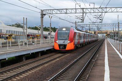 High-speed train arrives to railway station to pick up passengers to reach destination on nasty day