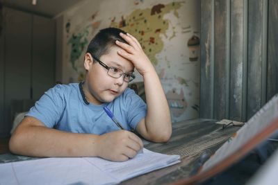 Side view of girl studying at home