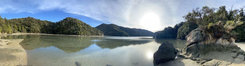 Panoramic view of lake by trees against sky