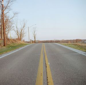 Empty road along trees